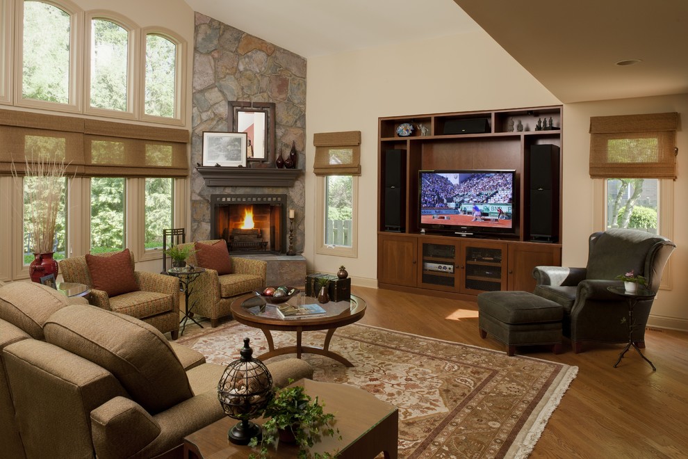 Photo of a large traditional open concept living room in Chicago with beige walls, medium hardwood floors, a corner fireplace, a stone fireplace surround and a built-in media wall.