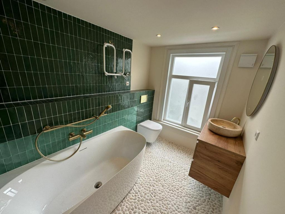Idee per una stanza da bagno mediterranea di medie dimensioni con vasca ad angolo, vasca/doccia, pareti beige, pavimento con piastrelle di ciottoli e lavabo a bacinella