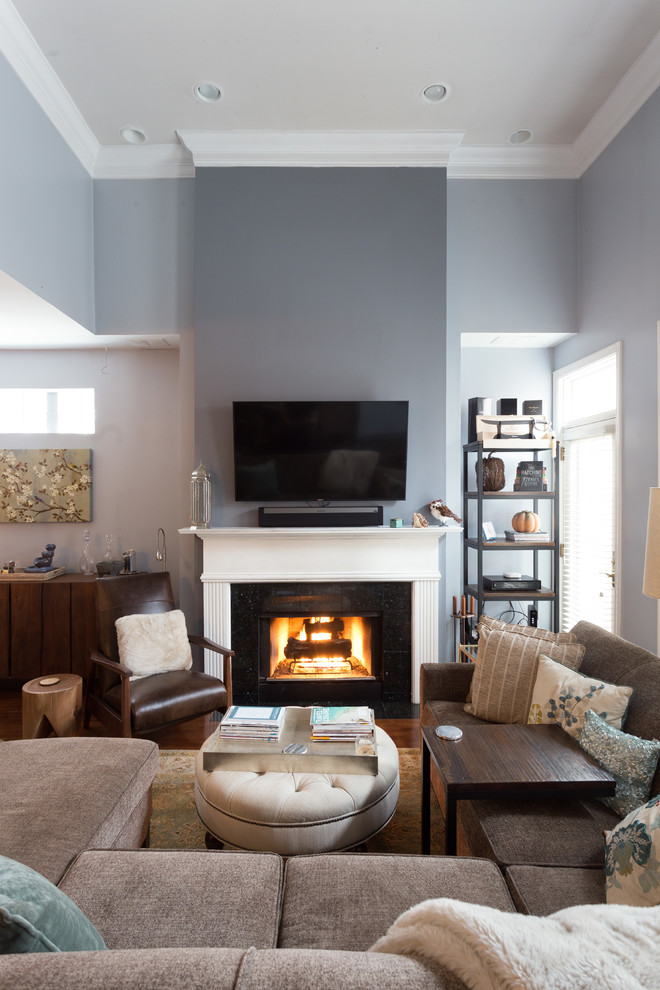 This is an example of a mid-sized contemporary formal enclosed living room in Chicago with blue walls, medium hardwood floors, a standard fireplace, a concrete fireplace surround and a wall-mounted tv.