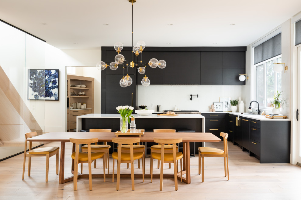 Large contemporary l-shaped eat-in kitchen in Calgary with an undermount sink, flat-panel cabinets, black cabinets, quartzite benchtops, white splashback, engineered quartz splashback, stainless steel appliances, light hardwood floors, with island, brown floor and white benchtop.