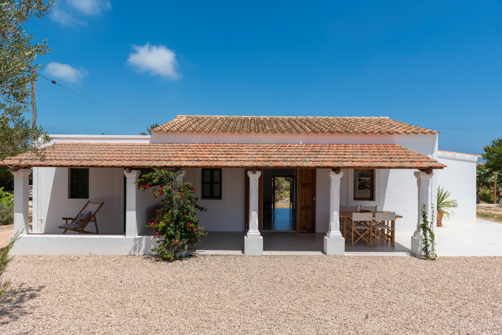 Inspiration pour une façade de maison blanche méditerranéenne en panneau de béton fibré de taille moyenne et de plain-pied avec un toit à deux pans, un toit en tuile et un toit marron.