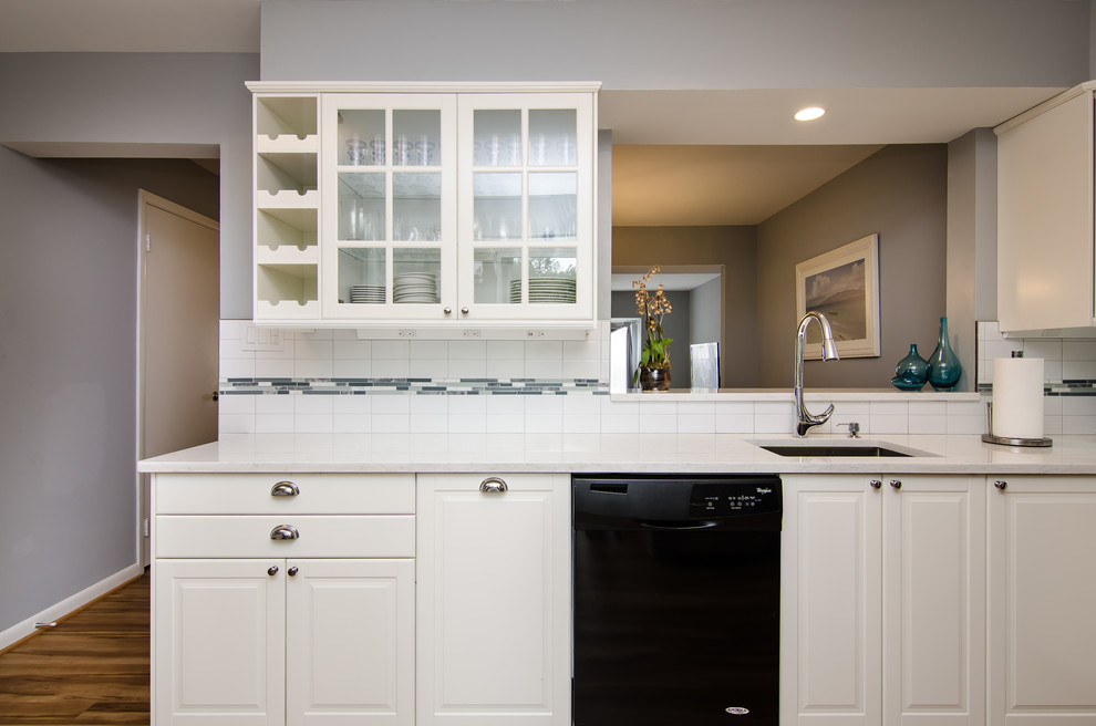 Inspiration for a mid-sized transitional l-shaped vinyl floor enclosed kitchen remodel in DC Metro with an undermount sink, shaker cabinets, quartz countertops, white backsplash, ceramic backsplash, black appliances and no island