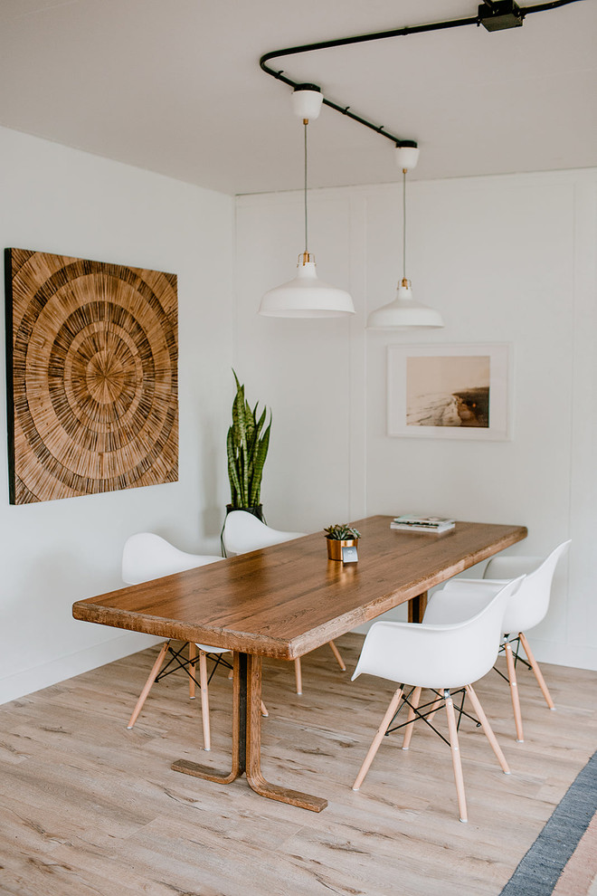 Mid-sized beach style dining room in Los Angeles with white walls, no fireplace, brown floor and light hardwood floors.