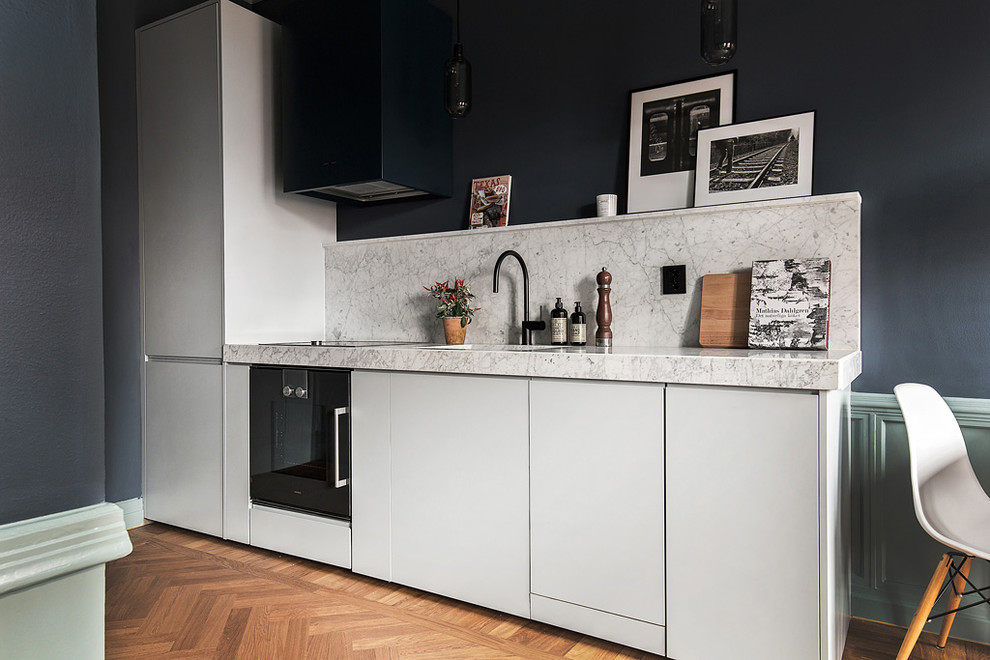 Mid-sized scandinavian kitchen in Stockholm with flat-panel cabinets, white cabinets and no island.