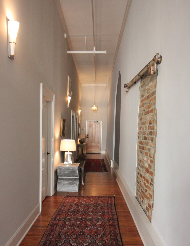 Entry hall - mid-sized industrial medium tone wood floor and brown floor entry hall idea in Atlanta with gray walls and a medium wood front door