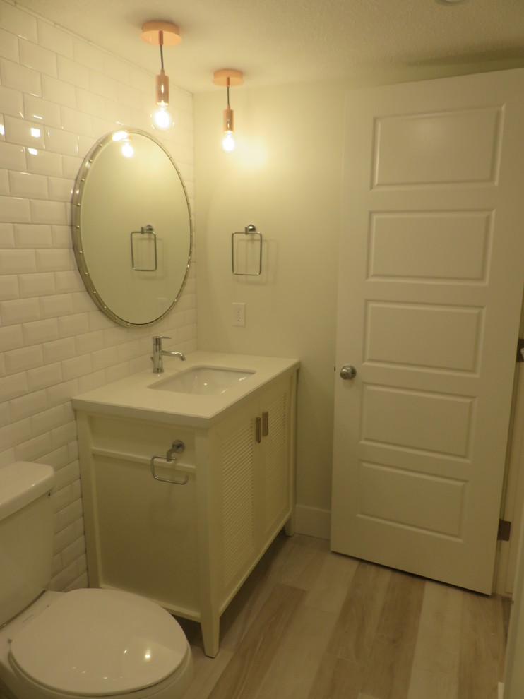 Small transitional kids' white tile and subway tile ceramic tile and gray floor alcove bathtub photo in Calgary with louvered cabinets, white cabinets, a two-piece toilet, white walls, an undermount sink and quartzite countertops