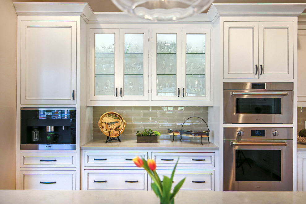 Large transitional u-shaped ceramic tile and beige floor eat-in kitchen photo in Charlotte with beaded inset cabinets, white cabinets, solid surface countertops, beige backsplash, glass tile backsplash, stainless steel appliances, an island and gray countertops