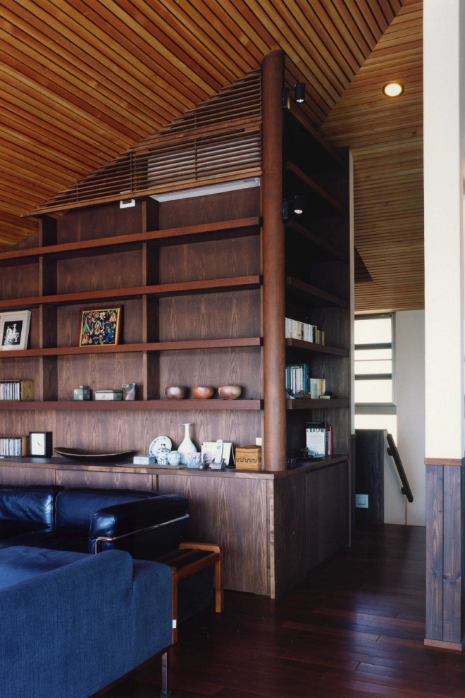 Photo of a mid-sized midcentury formal open concept living room in Tokyo with brown walls, dark hardwood floors, no fireplace, a freestanding tv, brown floor, wood and brick walls.