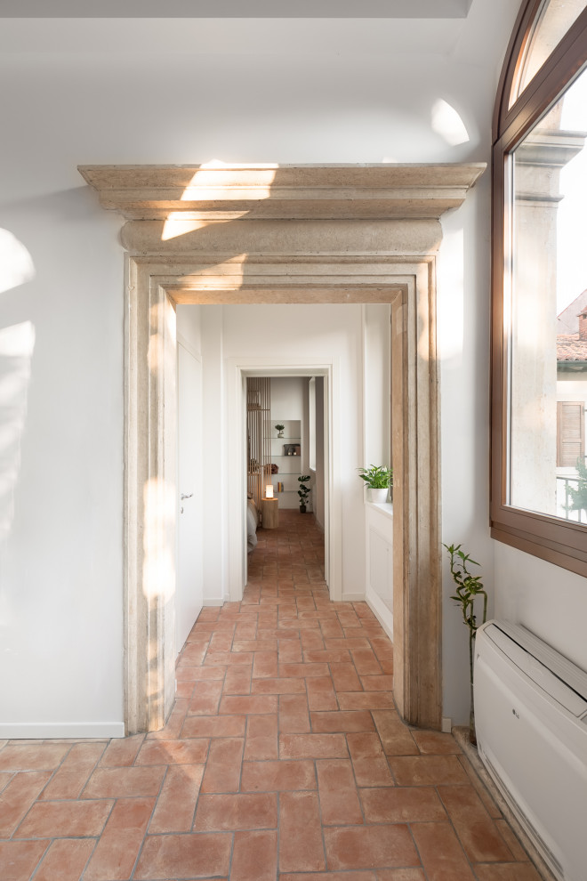 На фото: маленький коридор в современном стиле с белыми стенами, кирпичным полом, красным полом и многоуровневым потолком для на участке и в саду с