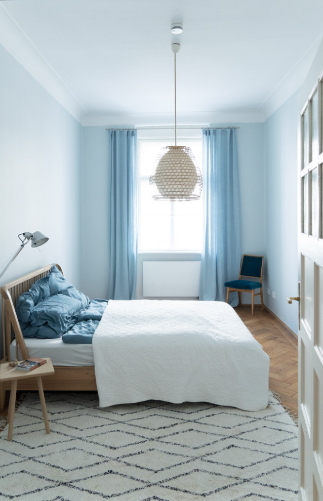 Mittelgroßes Skandinavisches Hauptschlafzimmer mit blauer Wandfarbe und braunem Holzboden in München