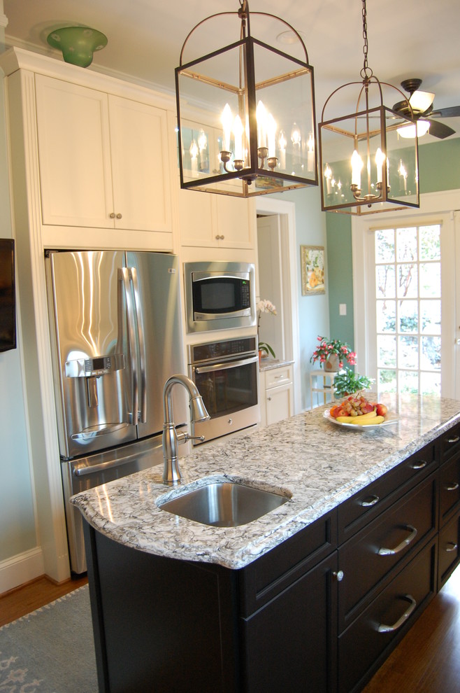 Inspiration for a transitional u-shaped eat-in kitchen remodel in Raleigh with an undermount sink, recessed-panel cabinets, white cabinets, quartzite countertops, white backsplash, subway tile backsplash and stainless steel appliances