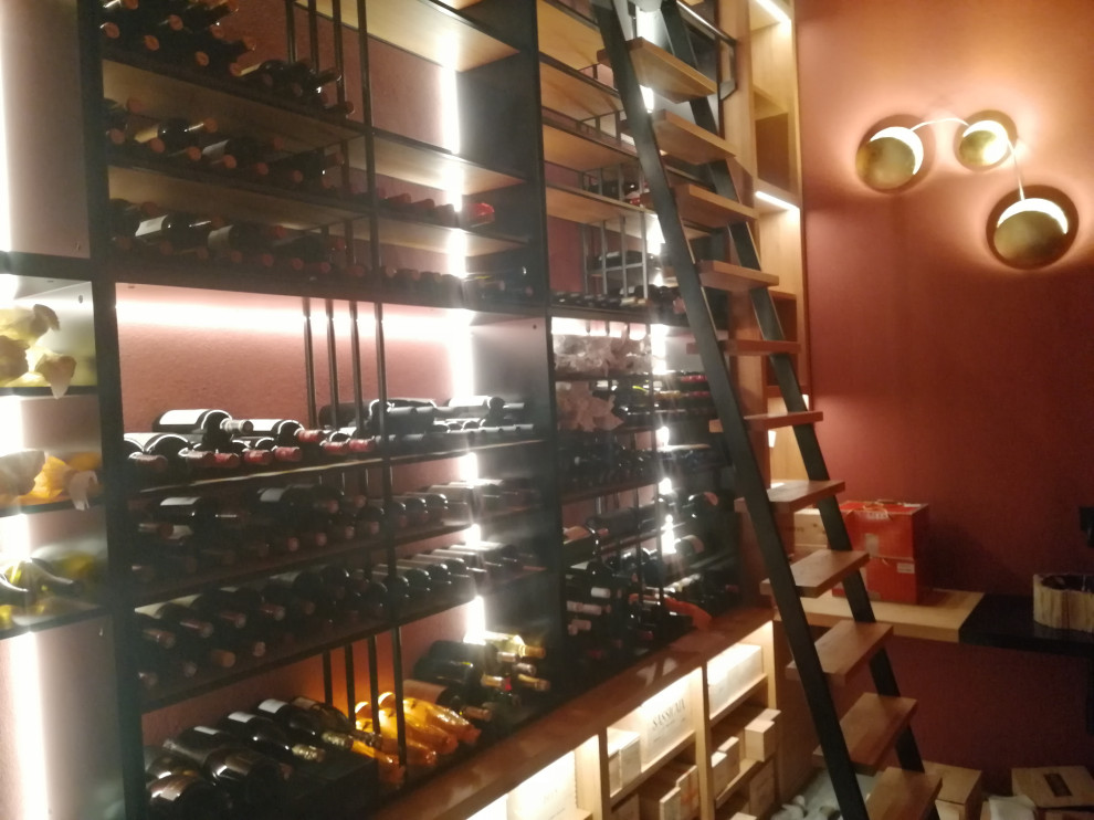 Design ideas for a mid-sized arts and crafts wine cellar in Milan with marble floors, display racks and grey floor.