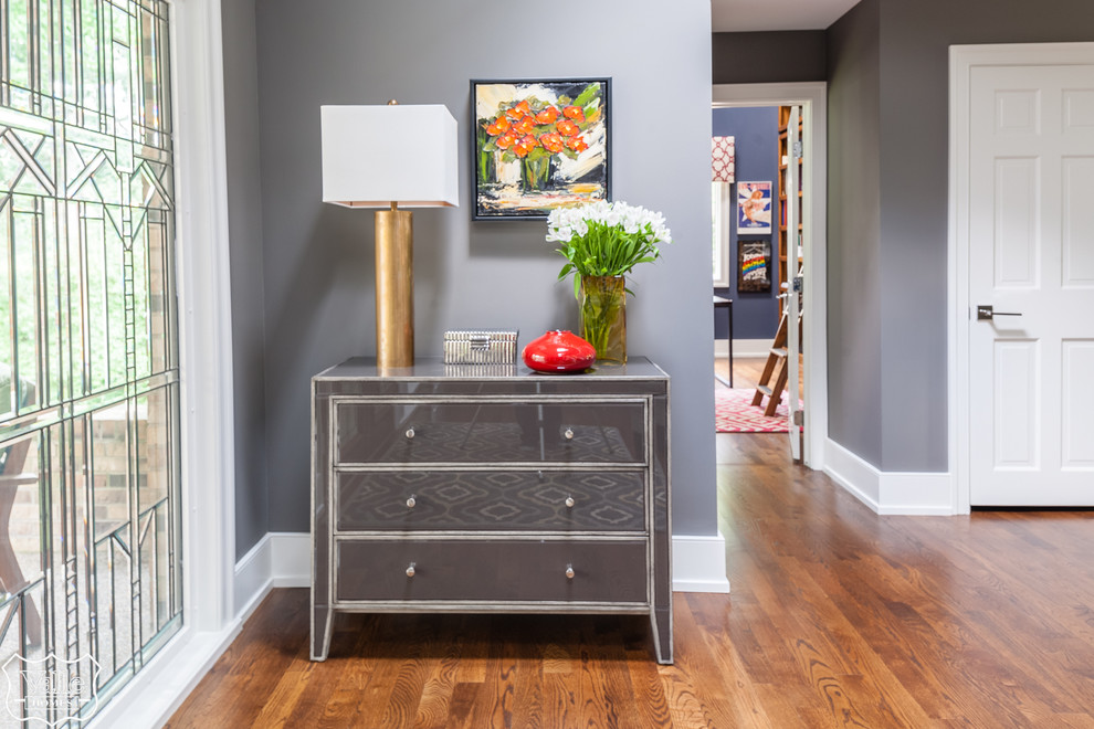 Huge transitional medium tone wood floor and brown floor front door photo with gray walls and a medium wood front door
