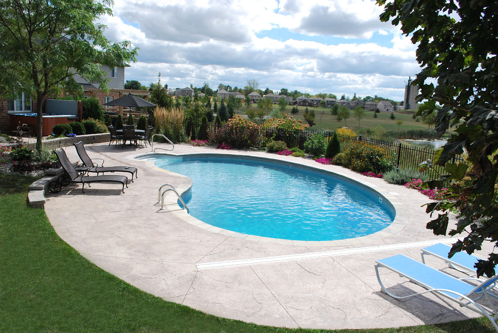 Mid-sized traditional backyard custom-shaped pool in Toronto with concrete slab.
