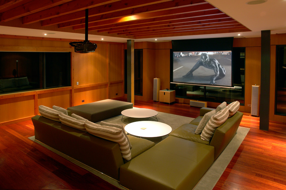 Réalisation d'une salle de cinéma minimaliste avec un sol en bois brun et un écran de projection.