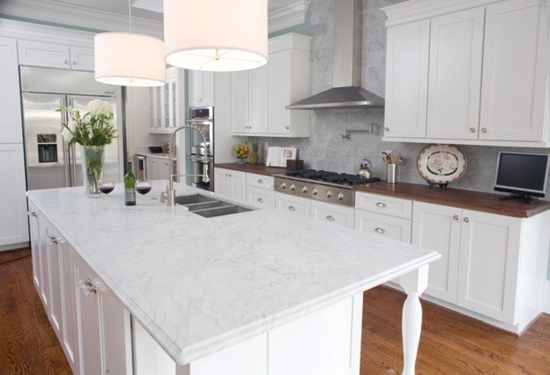 Mid-sized transitional l-shaped medium tone wood floor eat-in kitchen photo with a double-bowl sink, shaker cabinets, white cabinets, quartzite countertops, gray backsplash, stainless steel appliances and an island