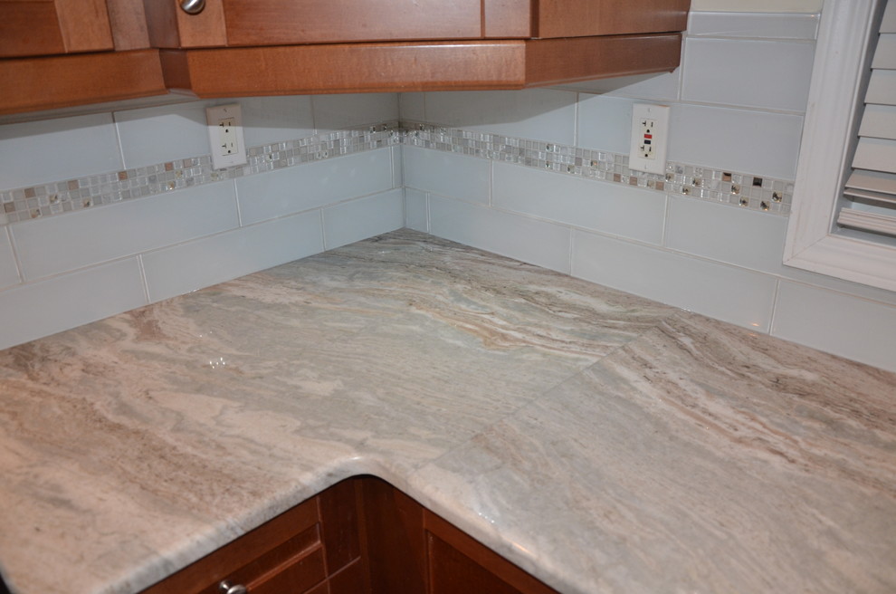 Home design - small transitional u-shaped porcelain tile home design idea in Toronto with a double-bowl sink, beaded inset cabinets, medium tone wood cabinets, granite countertops, white backsplash, glass tile backsplash, stainless steel appliances and no island