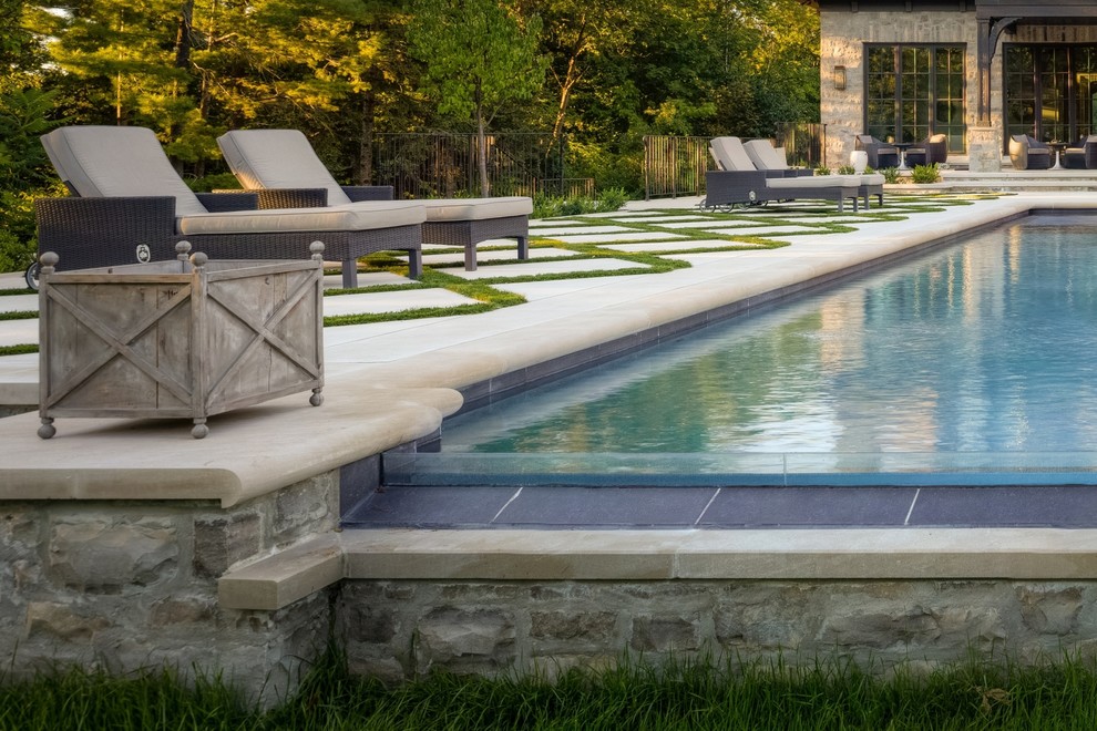 Photo of a mid-sized contemporary backyard rectangular infinity pool in Toronto with stamped concrete.