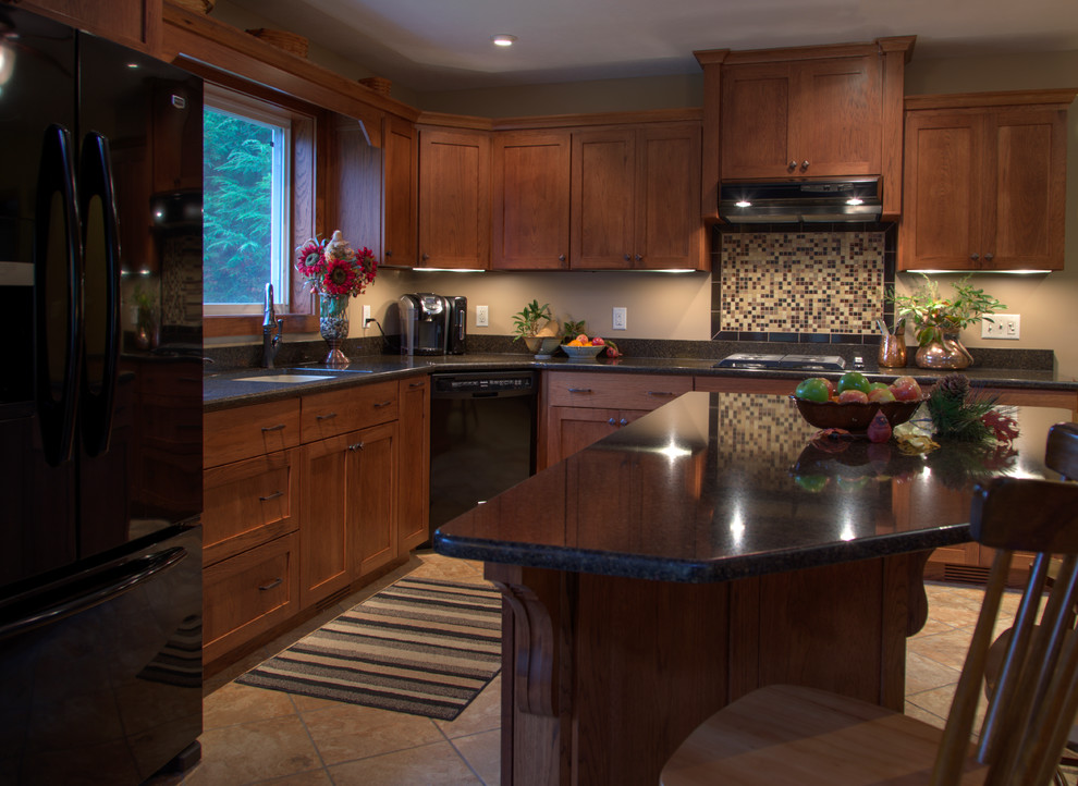 Example of a mid-sized mountain style l-shaped kitchen design with an undermount sink, shaker cabinets, light wood cabinets, granite countertops, multicolored backsplash, mosaic tile backsplash, black appliances and an island