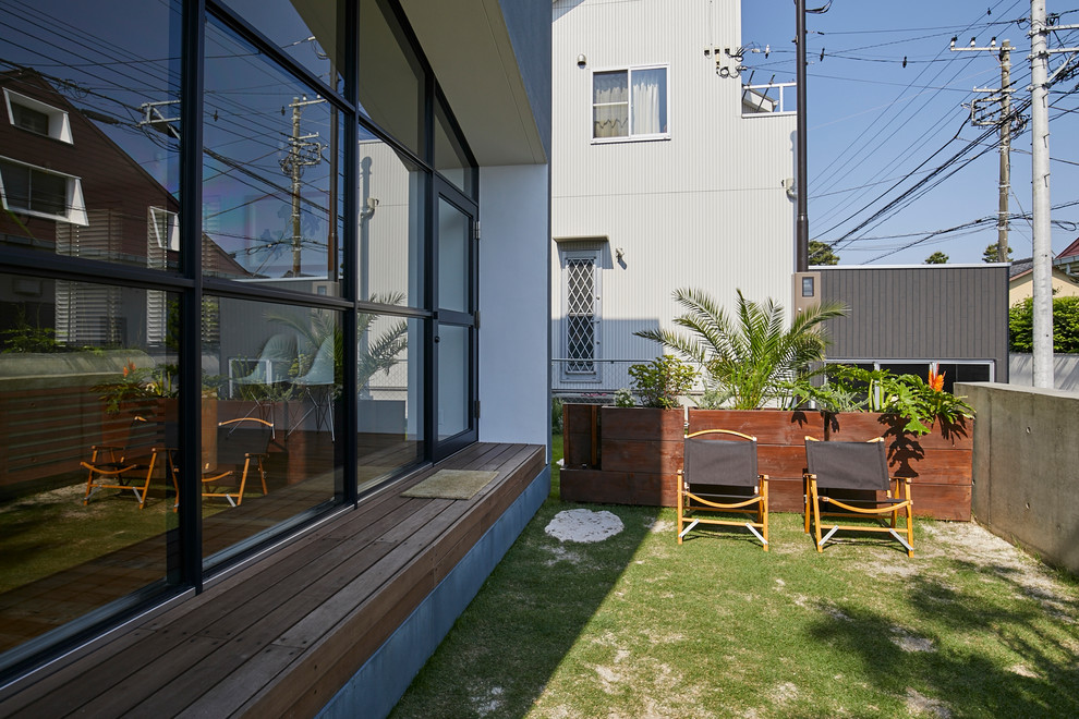 Inspiration for a small contemporary side yard patio in Other with a roof extension.