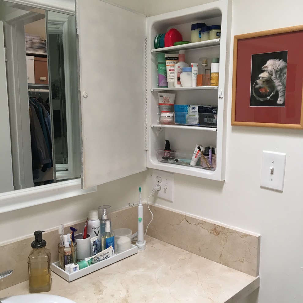 Design ideas for a small contemporary bathroom in Los Angeles with raised-panel cabinets, white cabinets and solid surface benchtops.