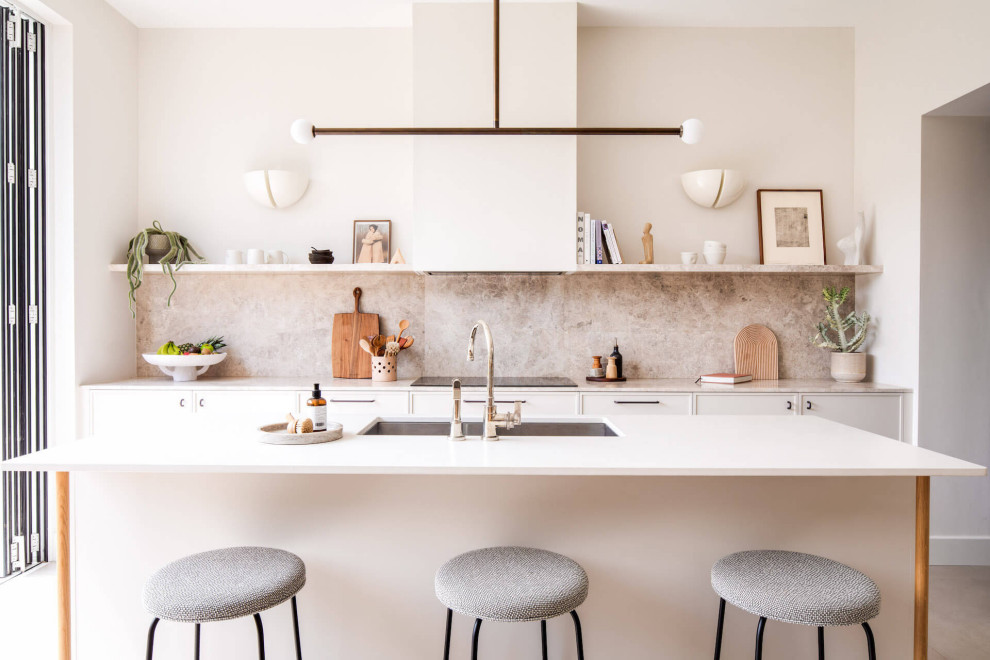 Inspiration for a large contemporary single-wall open plan kitchen in London with beaded cabinets, beige cabinets, marble worktops and an island.
