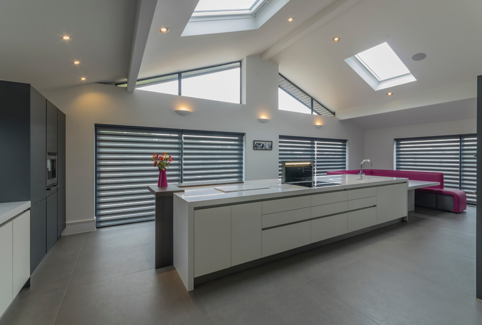 Photo of a contemporary kitchen in Cheshire with flat-panel cabinets, white cabinets and multiple islands.