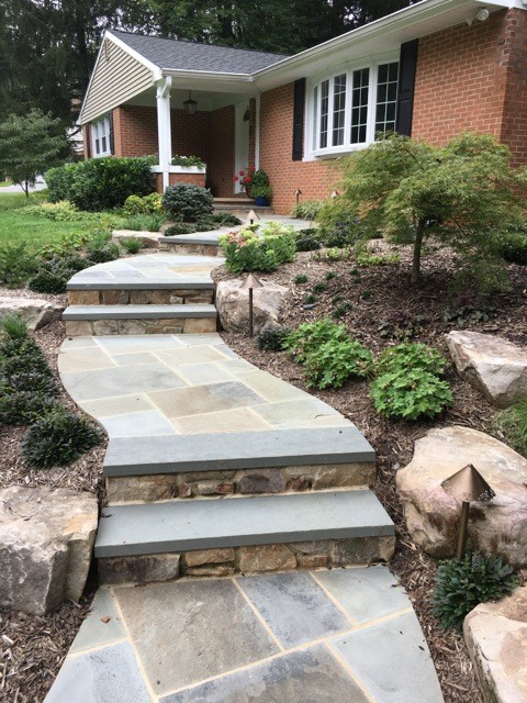 Photo of a mid-sized traditional front yard partial sun formal garden for summer in Baltimore with a garden path and natural stone pavers.