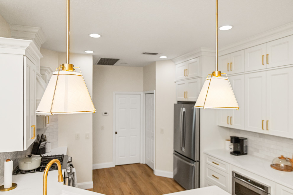 Inspiration for a small transitional l-shaped light wood floor and multicolored floor eat-in kitchen remodel in Tampa with an undermount sink, shaker cabinets, beige cabinets, quartzite countertops, beige backsplash, porcelain backsplash, stainless steel appliances, a peninsula and white countertops