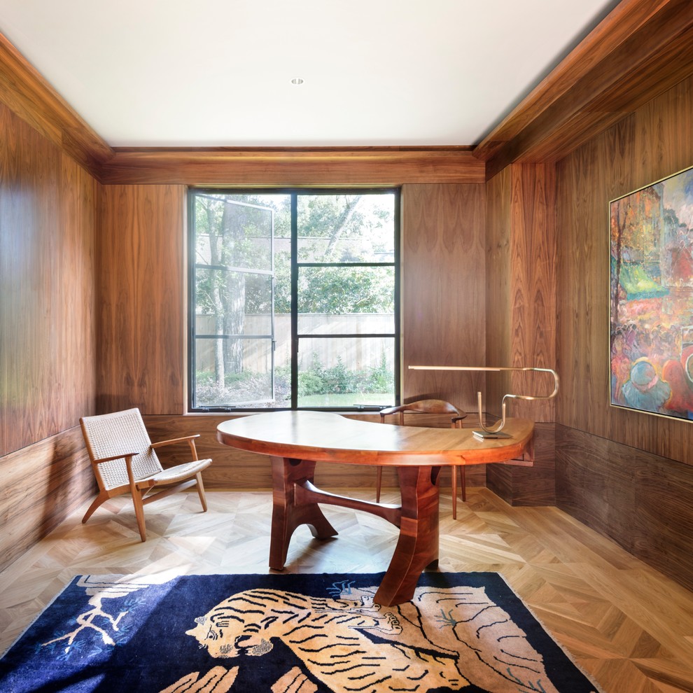 Inspiration for a midcentury study room in Houston with brown walls, medium hardwood floors and a freestanding desk.