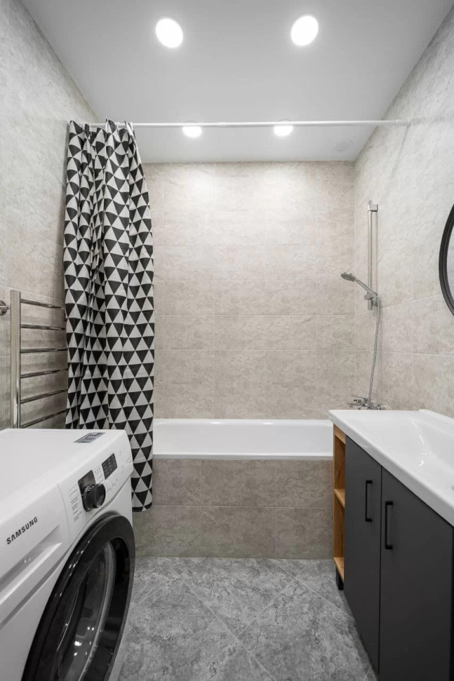 Пример оригинального дизайна: главная, серо-белая ванная комната среднего размера со стиральной машиной в современном стиле с плоскими фасадами, черными фасадами, полновстраиваемой ванной, душем над ванной, унитазом-моноблоком, серой плиткой, керамической плиткой, серыми стенами, полом из керамической плитки, накладной раковиной, столешницей из искусственного камня, серым полом, шторкой для ванной, белой столешницей, тумбой под одну раковину и напольной тумбой