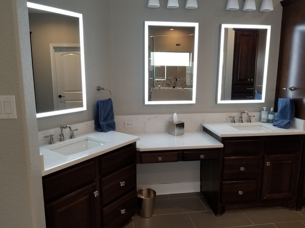 Photo of a mid-sized transitional master bathroom in Austin with raised-panel cabinets, dark wood cabinets, a freestanding tub, an alcove shower, a two-piece toilet, gray tile, porcelain tile, grey walls, porcelain floors, an undermount sink, engineered quartz benchtops, grey floor, a hinged shower door and white benchtops.