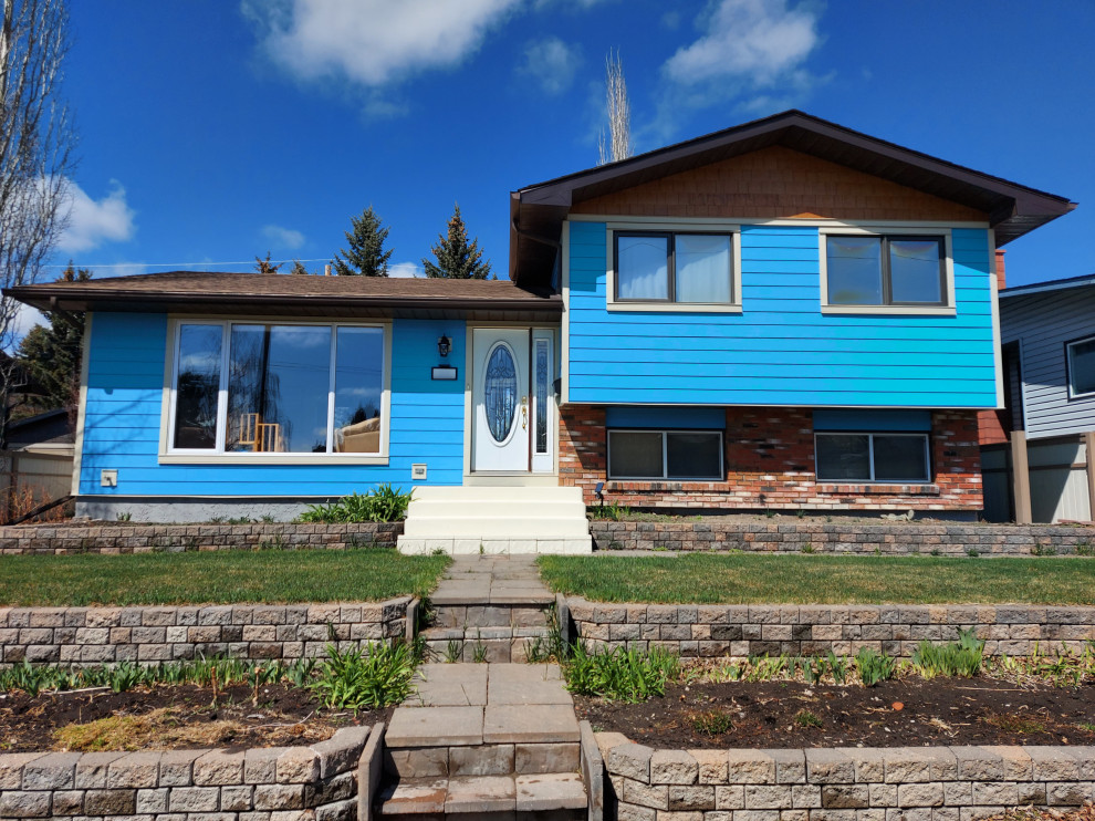 Photo of a medium sized and blue traditional split-level detached house in Calgary with concrete fibreboard cladding and shingles.