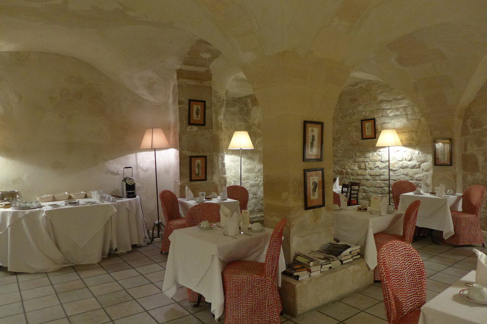 Exemple d'une salle à manger tendance avec un mur beige et tomettes au sol.