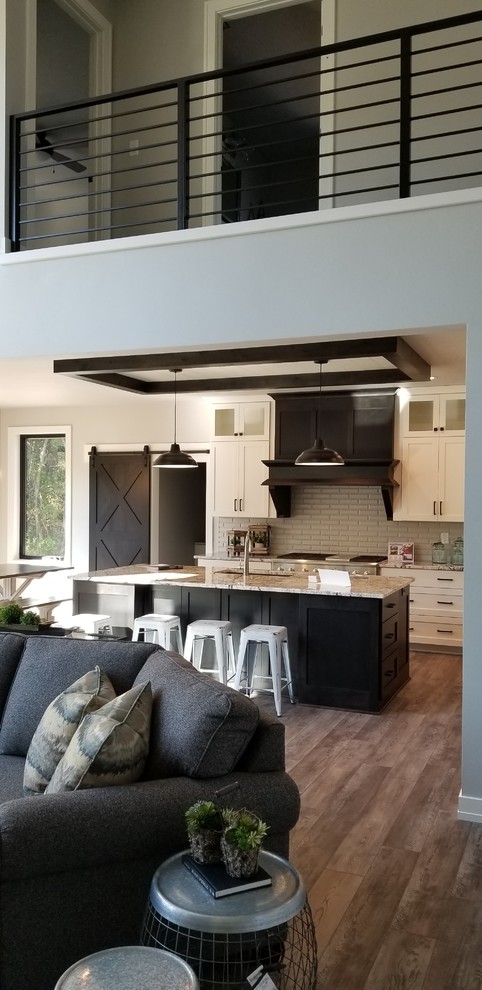 Photo of a large transitional galley eat-in kitchen in Milwaukee with granite benchtops, grey splashback, subway tile splashback, with island, brown floor and multi-coloured benchtop.
