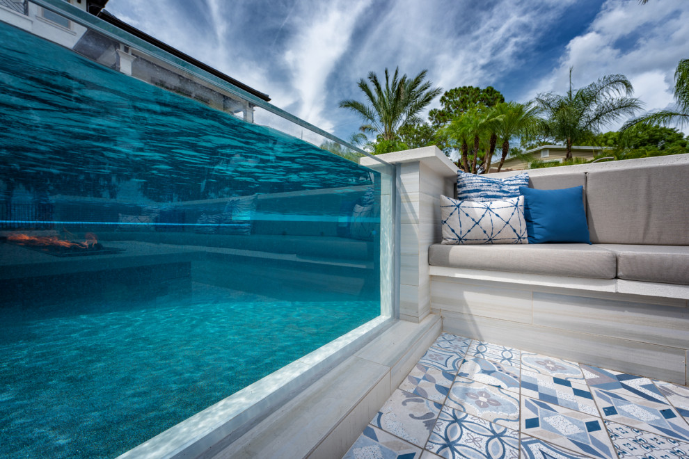 Inspiration for a large contemporary backyard custom-shaped infinity pool in Tampa with with a pool and tile.