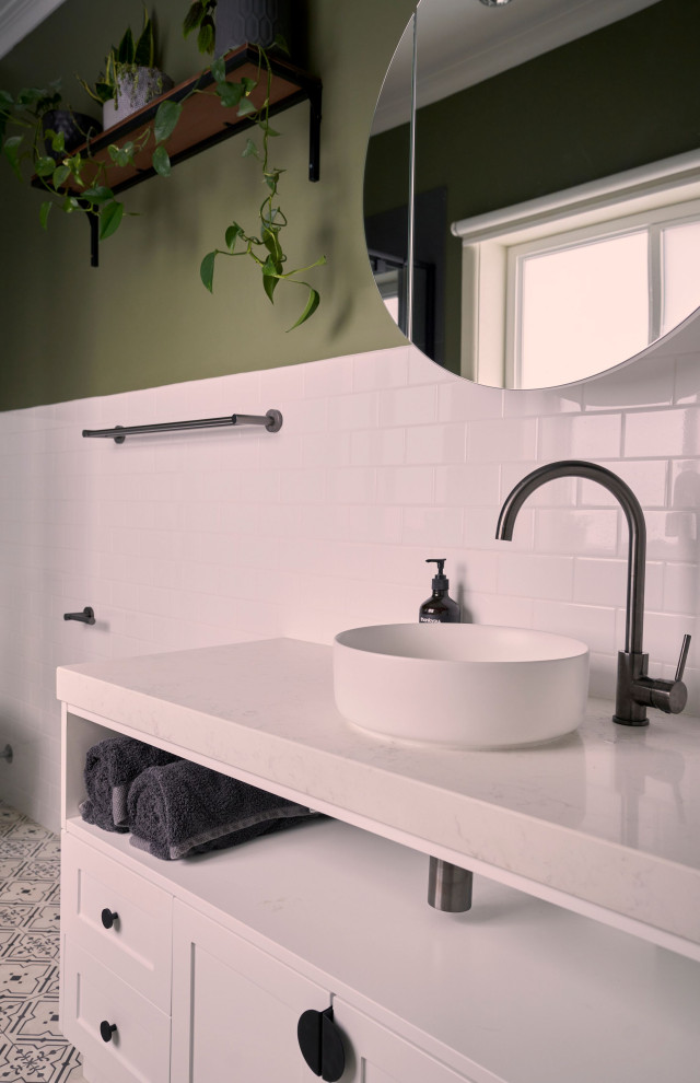 Mid-sized contemporary bathroom in Melbourne with recessed-panel cabinets, white cabinets, a corner shower, a one-piece toilet, white tile, ceramic tile, green walls, cement tiles, a vessel sink, engineered quartz benchtops, a hinged shower door, white benchtops, a niche, a single vanity and a built-in vanity.