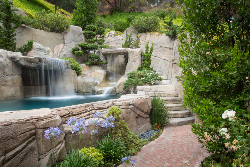 Photo of an eclectic natural pool in Austin with a water feature.