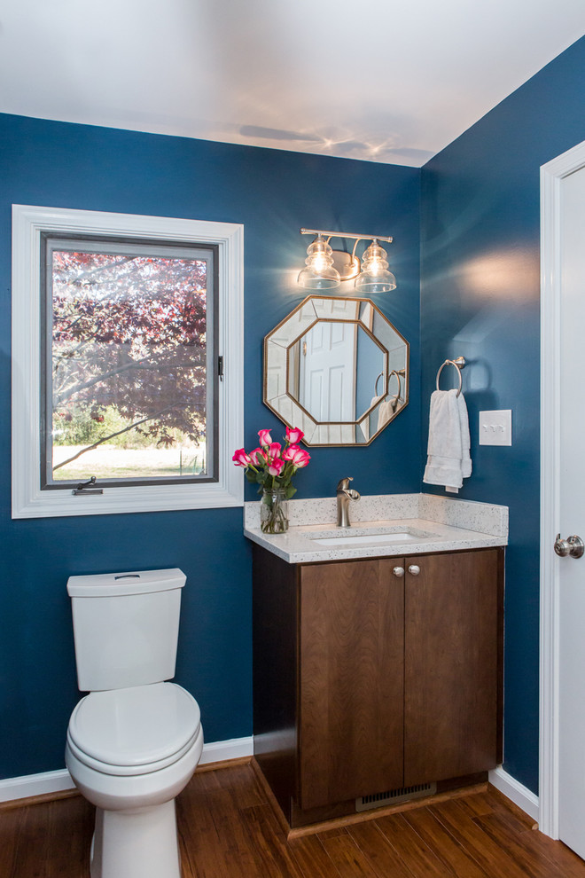 Inspiration for a small modern powder room in Raleigh with flat-panel cabinets, dark wood cabinets, a two-piece toilet, white tile, subway tile, blue walls, dark hardwood floors, an undermount sink, laminate benchtops and brown floor.