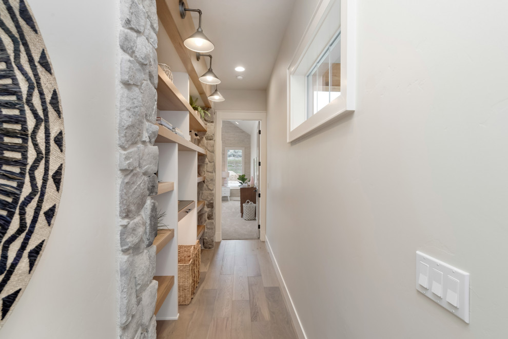 Design ideas for a mid-sized country hallway in Boise with grey walls, light hardwood floors and beige floor.