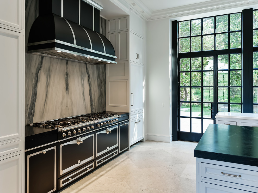 Expansive traditional eat-in kitchen in Dallas with an undermount sink, recessed-panel cabinets, white cabinets, onyx benchtops, grey splashback, stone slab splashback, white appliances, limestone floors, multiple islands, beige floor and black benchtop.