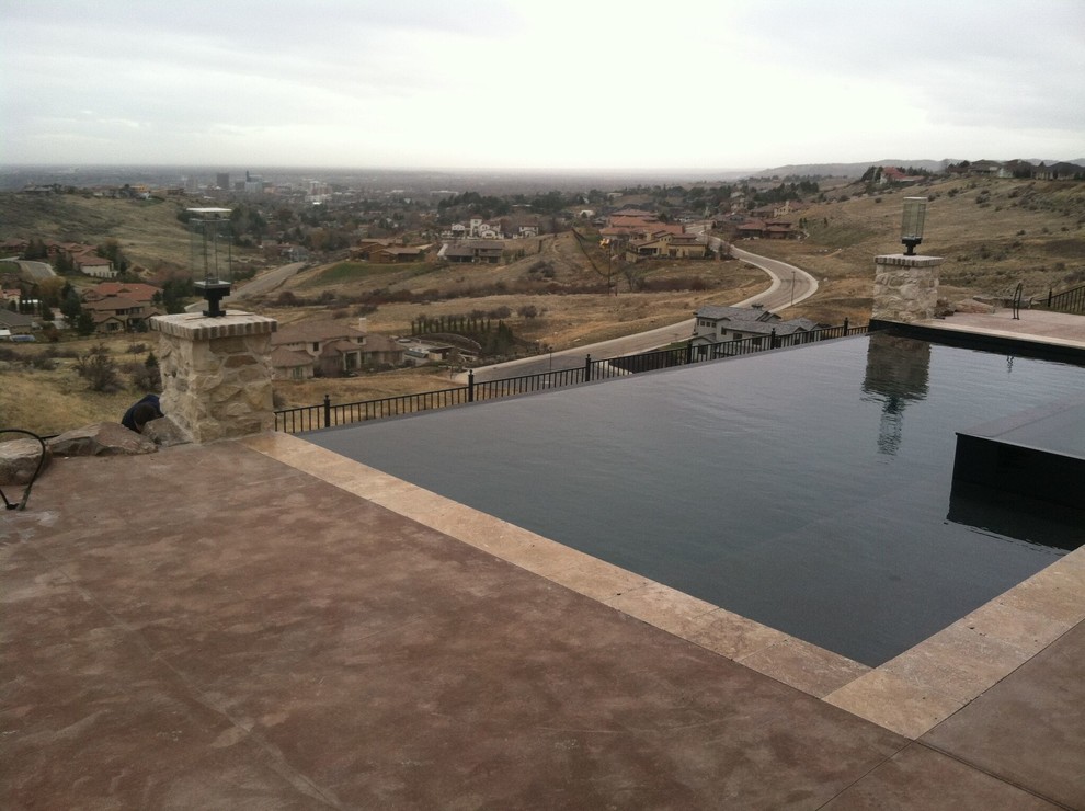 Example of a mid-sized transitional backyard rectangular and concrete infinity pool design in Boise