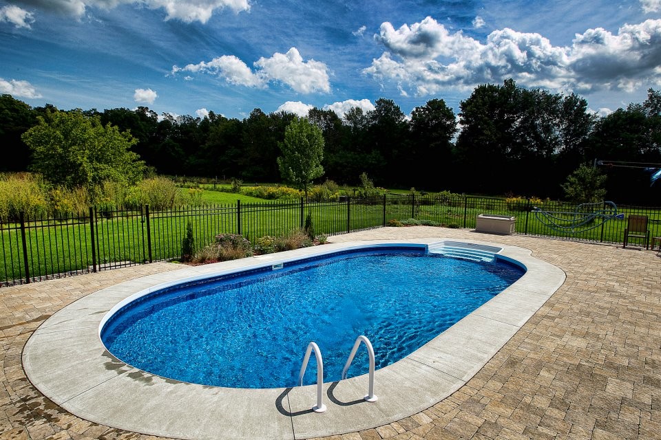 Design ideas for a mid-sized modern backyard round pool in Ottawa with concrete pavers.
