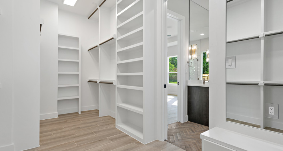 Photo of a large country gender-neutral walk-in wardrobe in Austin with shaker cabinets, white cabinets, ceramic floors and beige floor.
