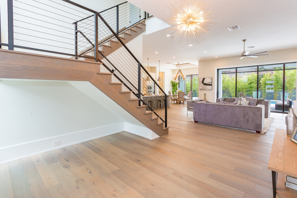 Large transitional wood u-shaped staircase in Orlando with wood risers and metal railing.