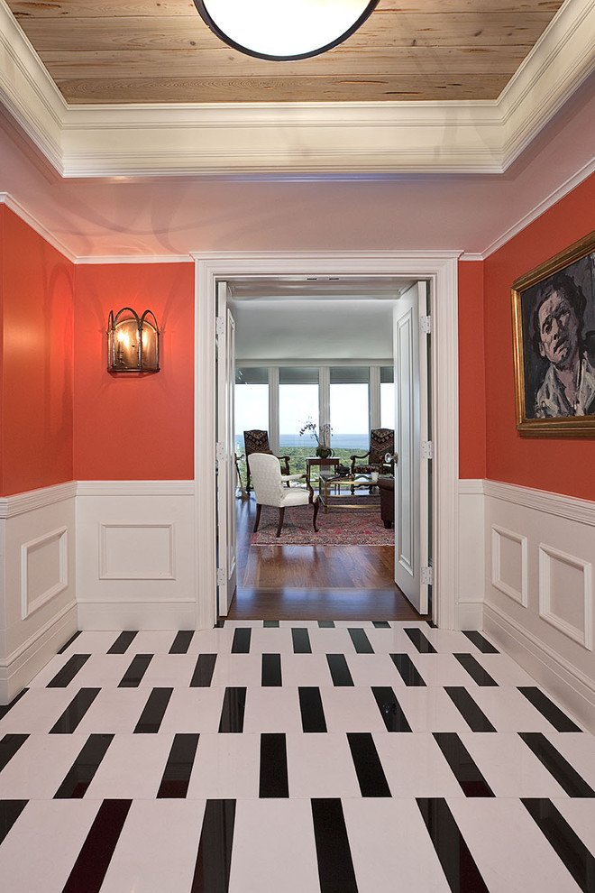 Eclectic hallway in Miami with red walls and multi-coloured floor.