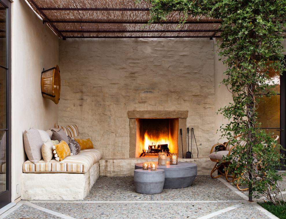 Photo of a large mediterranean patio in Santa Barbara with with fireplace and a pergola.