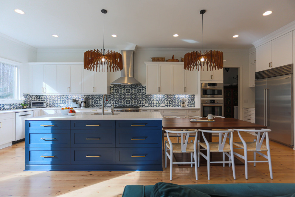 Open concept kitchen - large transitional u-shaped light wood floor and beige floor open concept kitchen idea in Raleigh with an undermount sink, shaker cabinets, white cabinets, blue backsplash, mosaic tile backsplash, stainless steel appliances, an island and white countertops