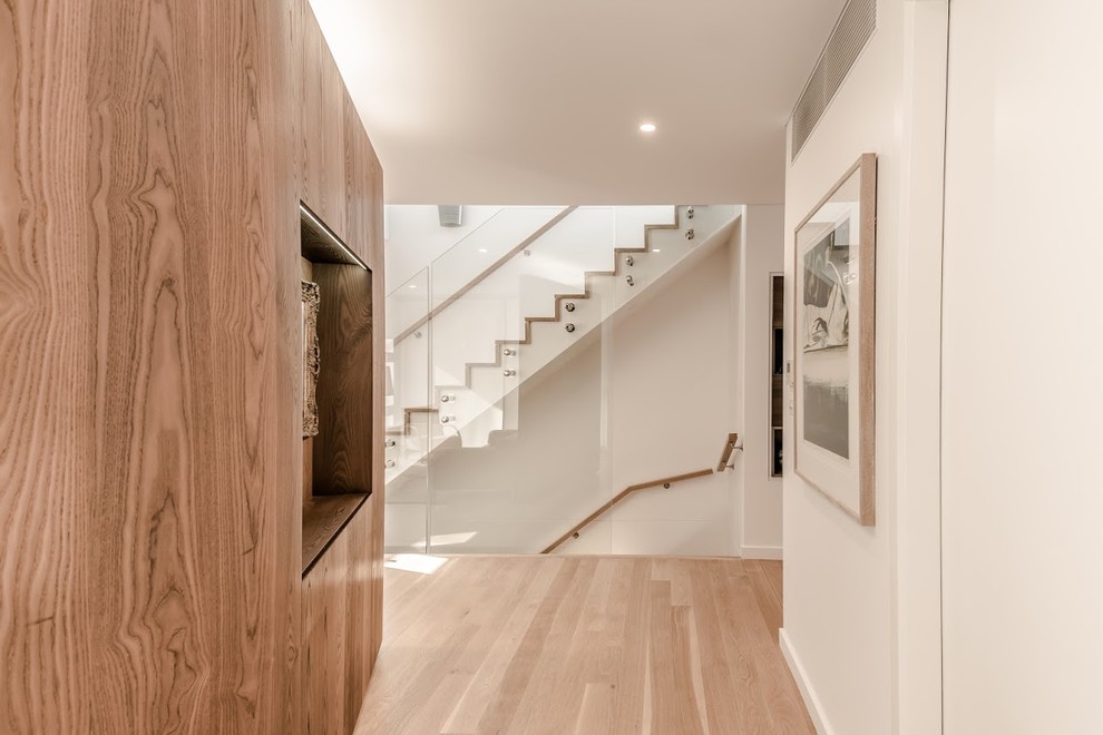 Inspiration for a contemporary hallway in Sydney with white walls and light hardwood floors.