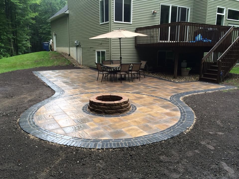 Large traditional backyard patio in Grand Rapids with a fire feature, concrete pavers and no cover.